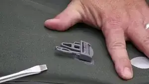Vorsichtig die beschädigte Schnalle mit einem Schlitzschraubenzieher heraushebeln.