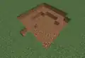 Breiterer, flacherer Krater eines Creepers, der fast 1 Block über dem Erdboden explodiert ist