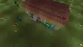 Eine Gruppe von Zombies belagert die Tür eines vom Spieler gebauten Hauses.