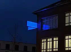 von – bis – hier von Nikolaus Koliusis, 2021, bei Nacht, an der Fassade der Wandel-Hallen in Reutlingen