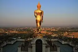 Schreitender Buddha vom Wat Phra That Khao Noi blickt über die Stadt
