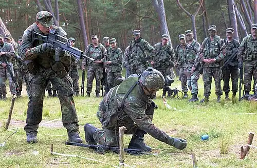 Deutsche Soldaten (Vordergrund) im&nbsp;Feldanzug, Tarndruck