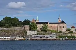 Foto einer Festung mit zwei Türmen und einem Gewässer im Vordergrund