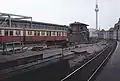 Östli­cher Bahnhofs­kopf mit S-Bahn-Zug der Bau­reihe ET&nbsp;165 der BVG am Bahn­steig&nbsp;C und dem Stell­werk Frio, Septem­ber 1990