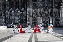 Vor der Fassade des Kölner Doms sind rote und weiße, ca. 1,50&nbsp;m hohe Buchstaben aufgestellt, die das Wort „Alaaf“ bilden.
