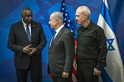 Drei Männer vor der US-amerikanischen und der israelischen Flagge