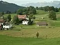 Blick auf einen Teil der Abdeckung der Festung. Vorne rechts Nebeneingang zur Anlage, dahinter ein Panzerturm, links daneben hinter den Bäumen ein Mg-Bunker