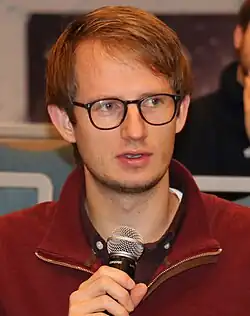 Foto eines Mannes, der in ein Mikrofon spricht