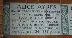 A tablet formed of six standard sized tiles, bordered by green flowers in the style of the Arts and Crafts movement