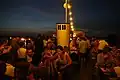Partygäste auf dem Oberdeck mit abendlicher Aussicht über Sendling
