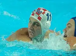 Anđelo Šetka ist im Wasser. Er trägt die mit weiß-roten Quadraten gekennzeichnete Bademütze mit der Nummer 11.
