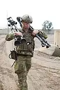 Australischer Soldat mit zwei zusammengeklappten Dreibeinen