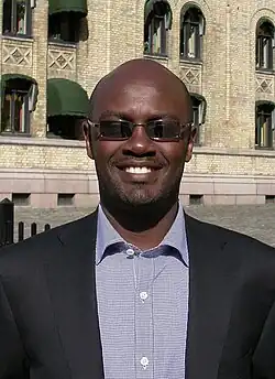 Andrew Mwenda, ein Mann im Anzug, lächelt