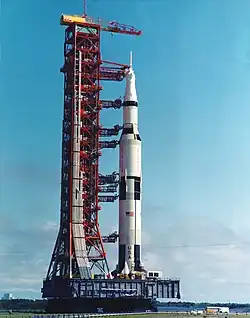 Eine Saturn-V mit Versorgungsturm auf einem MLP, darunter der Crawler