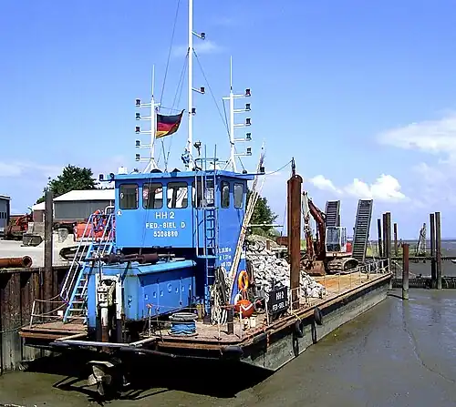 Ein trockengefallener Arbeitsponton im Hafen von Fedderwardersiel