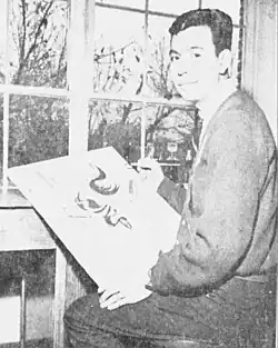 Arthur Amiotte, sitzend, mit einer Bildleinwand und einem Pinsel im Jahr 1965