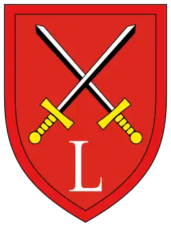 Ein rotes Wappen mit zwei gekreuzten Schwertern (mit gelben Griffen) und dem Buchstaben L in weiss