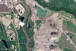 Links: Satellitenaufnahme des nördlichen Teils der „Millennium Mine“ der Suncor Energy und angeschlossene Infrastruktur. Der große Fluss in der linken Bildhälfte ist der Athabasca River. Rechts: Teil des Tagebaus sowie Schwefelhalden und Absetzbecken („Syncrude tailings pond“) der Aufbe­reitungs­anlage „Mildred Lake“ von Syncrude.