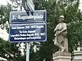 Straßenschild 7.,&nbsp;Augustinplatz. Darunter Zusatztafel mit den biografischen Grunddaten des Namensgebers und der Namensgeberin, nach denen der Platz im Mai 2009 benannt wurde.