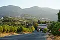 Babadağ von Norden her (vom Babadağ Sarayköy Yolu aus photographiert) im Jahre 2021. Auf den Bergen im Hintergrund kann man schwach die im Jahre 2020 ans Netz gegangenen Windenergieanlagen erkennen.
