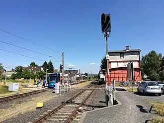 Bahnhofsgebäude und abfahrbereiter Zug der Linie 5