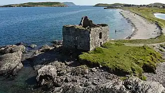 Luftaufnahme der Ruine des Tower Houses mit der Klosterruine im Hintergrund