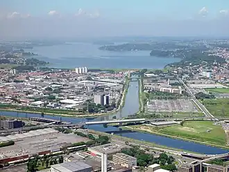Luftbild des Zusammenflusses von Rio Guarapiranga und Rio Grande zum Rio Pinheiros mit dem Guarapiranga-Stausee im Hintergrund.