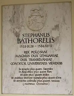 Farbfotografie einer Gedenktafel mit der Aufschrift „Stephanus Bathoreus 28.09.1533 – 12.12.1586 Rex Poloniae. Magnus Dux Lithuaniae. Dux Transilvaniae. Conditor Universitatis Vilnensis“. Eine Widmung von Martin Cromer steht darunter und an der Spitze ist ein Wappen mit einem Reiter.