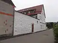 Ansicht vom ehemaligen Stadtgraben aus mit einem Teil der renovierten Stadtmauer (weiß)