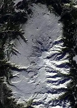 Überblick über ein ovales, schneebedecktes Plateau mit einem schneebedeckten Berg in der Mitte