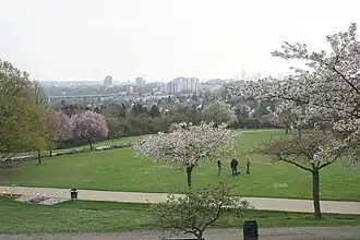 Frühling: Blick auf Seckbach mit ev. Marienkirche, Atzelberg und Hochhäusern der Innenstadt