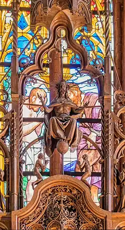 Gesprenge des Bordesholmer Altars: Christus als Weltenrichter auf dem Regenbogen sitzend, die Füße auf der Weltkugel; aus seinem Kopf ragen drei Schwerter, zu seinen Füßen knien anbetend zwei nackte Menschen, eine Verkörperung der Seelen