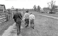 Soldat der Waffen-SS bei der Gefangennahme von Partisanen in Belarus. (Datierung Juli–August 1943. Das Bild wurde vermutlich während des Unternehmens Hermann aufgenommen)