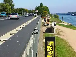 Rheinpegel an der Bundesstraße&nbsp;42. Die Anzeige am Pegelstab reicht bis 6&nbsp;Meter, bei 5,46&nbsp;Meter wird hier die Fahrbahn überspült. 1988 wurde hier ein Pegel von 5,80&nbsp;Meter erreicht.