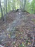 Ehemaliger Zugang mit Resten einer Mauer aus Findlingen