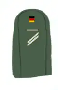 Ärmelabzeichen Obergefreiter UA am Arbeitsanzug, Moleskin ca. 1970–1974[A 13][36]