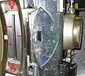 Die roten Pfeile markieren das Strahlaustrittsfenster der Röhre eines 16-Zeilen CTs. Rechts im Bild der Röhrentank; in den oben und unten angeschlossenen Rohrleitungen läuft die Kühlflüssigkeit zur Kühlung der Röhre.