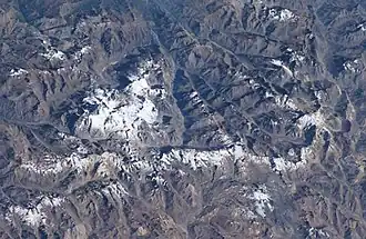 Ein Komplex schneebedeckter Kegel (Mitte links) erhebt sich in der 30 × 45 km weiten Caldera del Atuel.