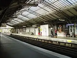 Station Cambronne der Linie 6: gemauerte Wände; Glasdach überspannt Bahnsteige und Gleise