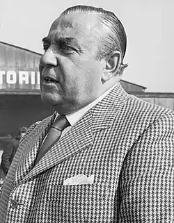 Dieses Porträtfoto in Schwarz-Weiß zeigt den italienischen Rennfahrer Carlo Abarth und ist rechtsseitig vom Brustkorb aufwärts aufgenommen. Das Foto entstand im Jahr 1971.
