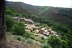 Cerdeira (Lousã) – Schieferdorf in der Serra da Lousã, Portugal, das sich in das Tal schmiegt, aus mit Steinen gedeckten Häusern mit flach geneigten Dächern, welche durch Braun-, Rot- und Grautöne der Steine recht bunt wirken.