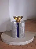 Die Taufe auf dem Sockel mit der „3“, auf den auch eine Vase gestellt werden kann