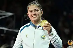 Diyora Keldiyorova im weißen Trainingsanzug nach der Siegerehrung.