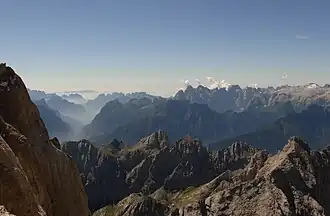 Die Cima Pape o Sanson (grasiger Gipfel in der Mitte), links knapp dahinter die Pale di San Lucano (Spitze Gipfel links sind die Cime d' Ambrusogn, der breite Gipfel in der Mitte der Monte San Lucano), für weitere Details siehe File:Dolomitai4.JPG.