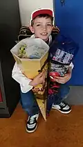 Kind mit zwei Zuckertüten im Jahr 2024, mit Spiderman und Minions bedruckt.