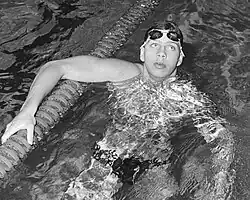 Auf diesem Schwarzweißfoto stützt sich Schlingemann nach der Zielankunft auf der Trennleine ab. Er hat seine Schwimmbrille nach oben geschoben.