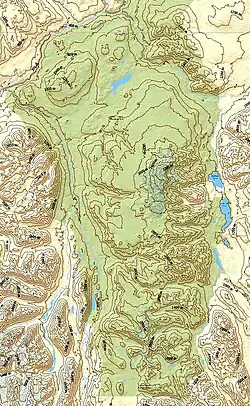 Eine gelb und grün gestaltete Karte mit der Darstellung einer Gebirgslandschaft durch Konturlinien