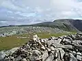 Der Gipfelcairn des Eididh nan Clach Geala, im Hintergrund der Meall nan Ceapraichean und der Beinn Dearg