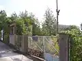 Das Schrankenwärter­haus als Überbleibsel des östlichen Bahn­übergangs. Direkt hinter dem Tor befand sich der Betriebsbahnhof. (Aufnahme 2007)