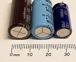 Durch Prägen eingebrachte Sollbruchlinien in den Becherböden von Aluminium-Elektrolytkondensatoren